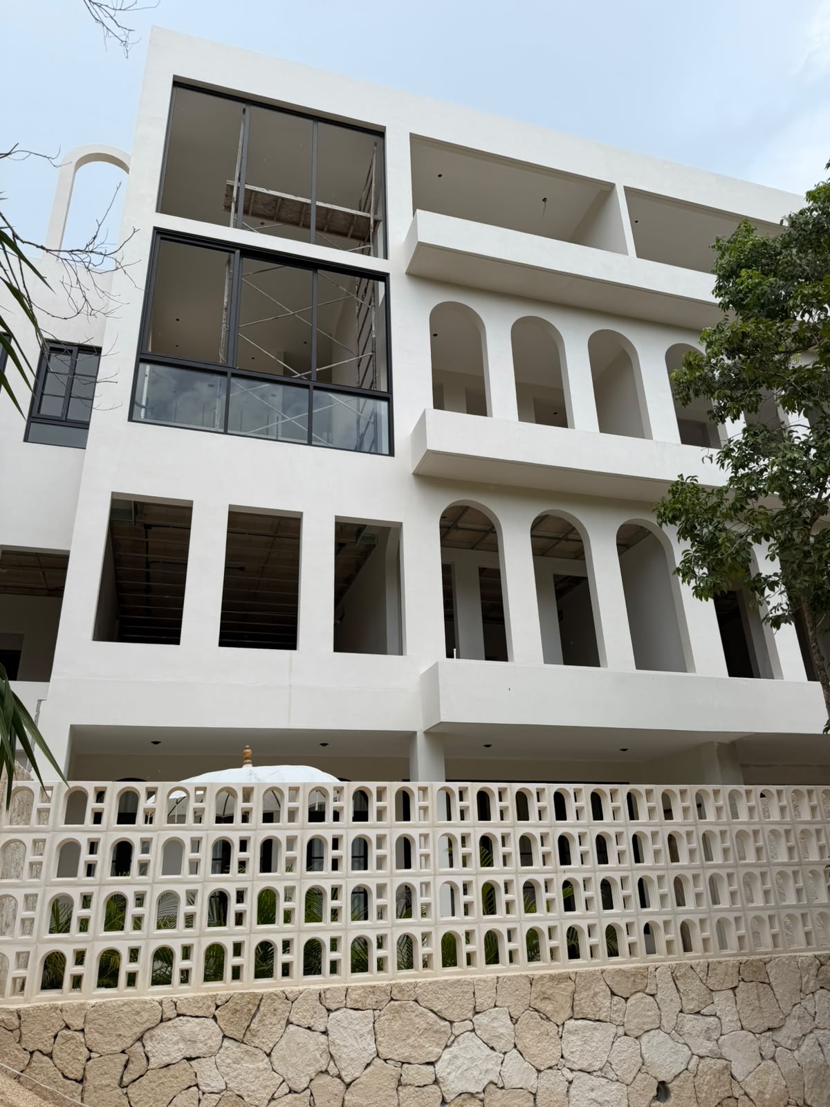 Mediterranean exterior facade, architectural arches, breeze block screen and artisan limestone base
