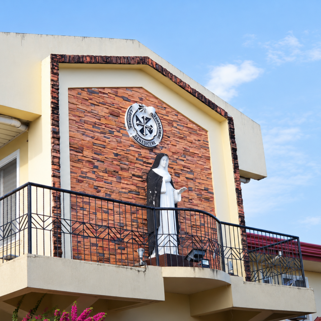Architectural facade detail of Omura Homes showing the balcony and emblem.