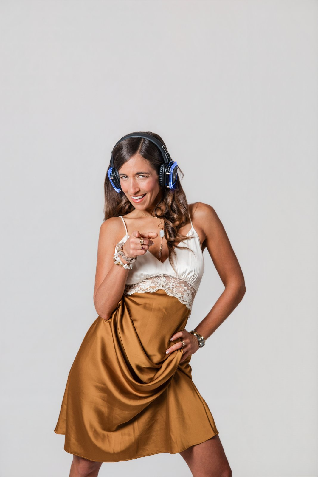 Schoschanna Joy pointing forward wearing glowing THE FIELD silent disco headphones