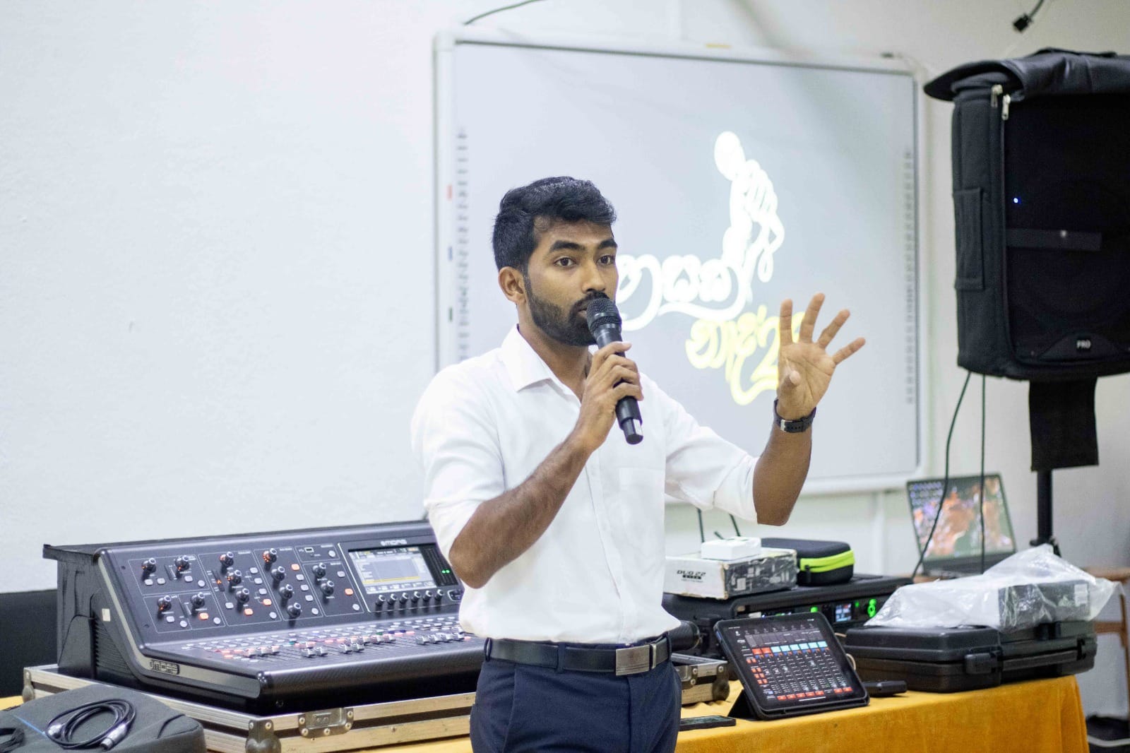 Instructor demonstrating live mixing console techniques to students during an audio workshop
