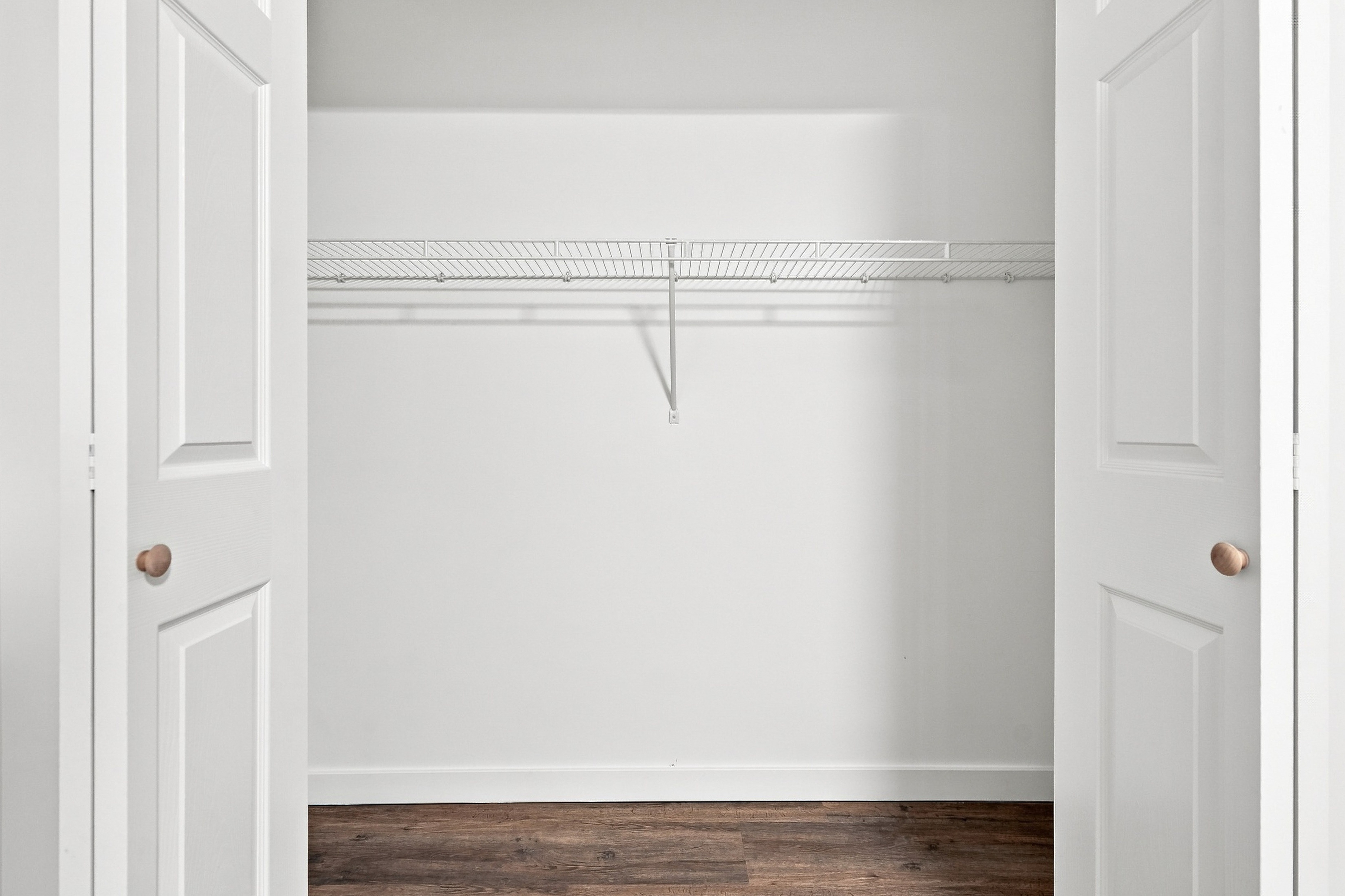 Built-in bedroom closet with double bifold doors and wire shelving