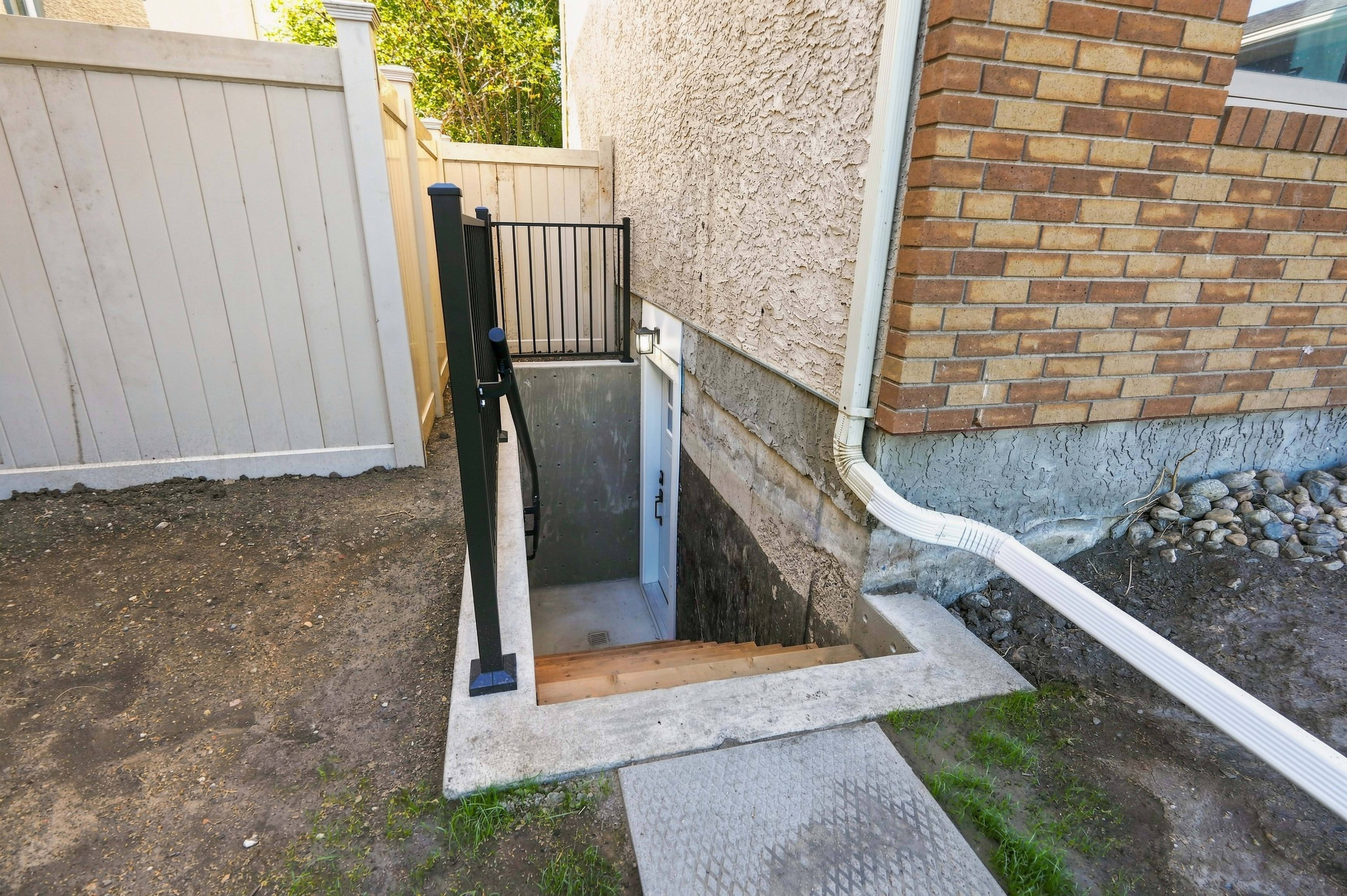 Private concrete side entrance and stairway with railing leading to the suite door