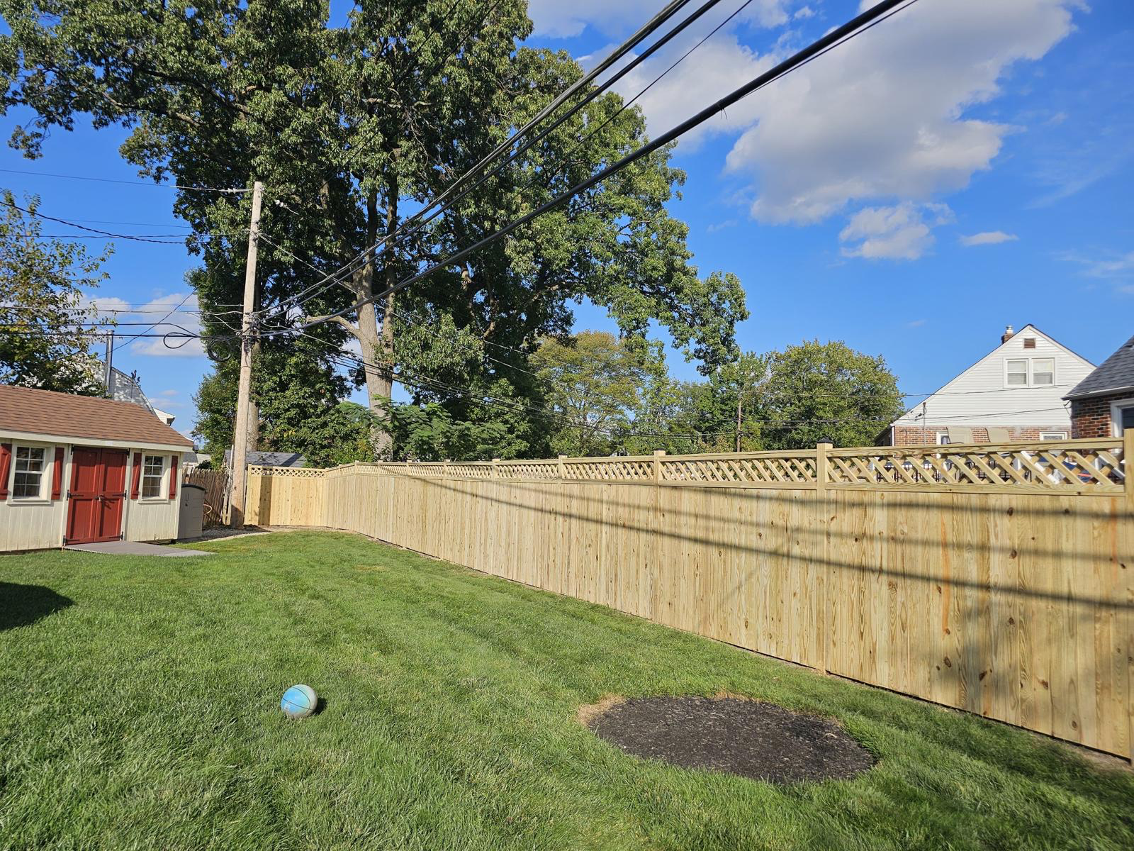 Custom wood privacy fence with lattice top installed by JA Fencing LLC