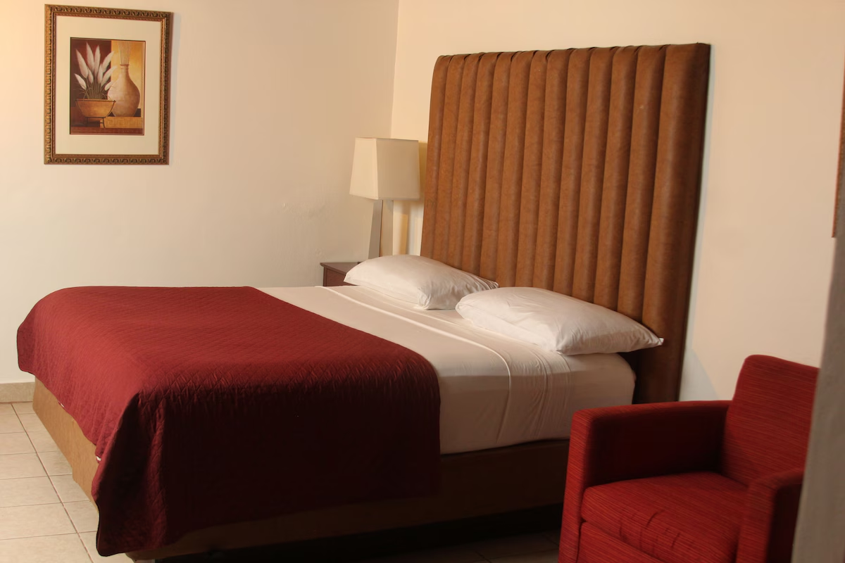 Stafford Lodge King Room with plush bedding and armchair