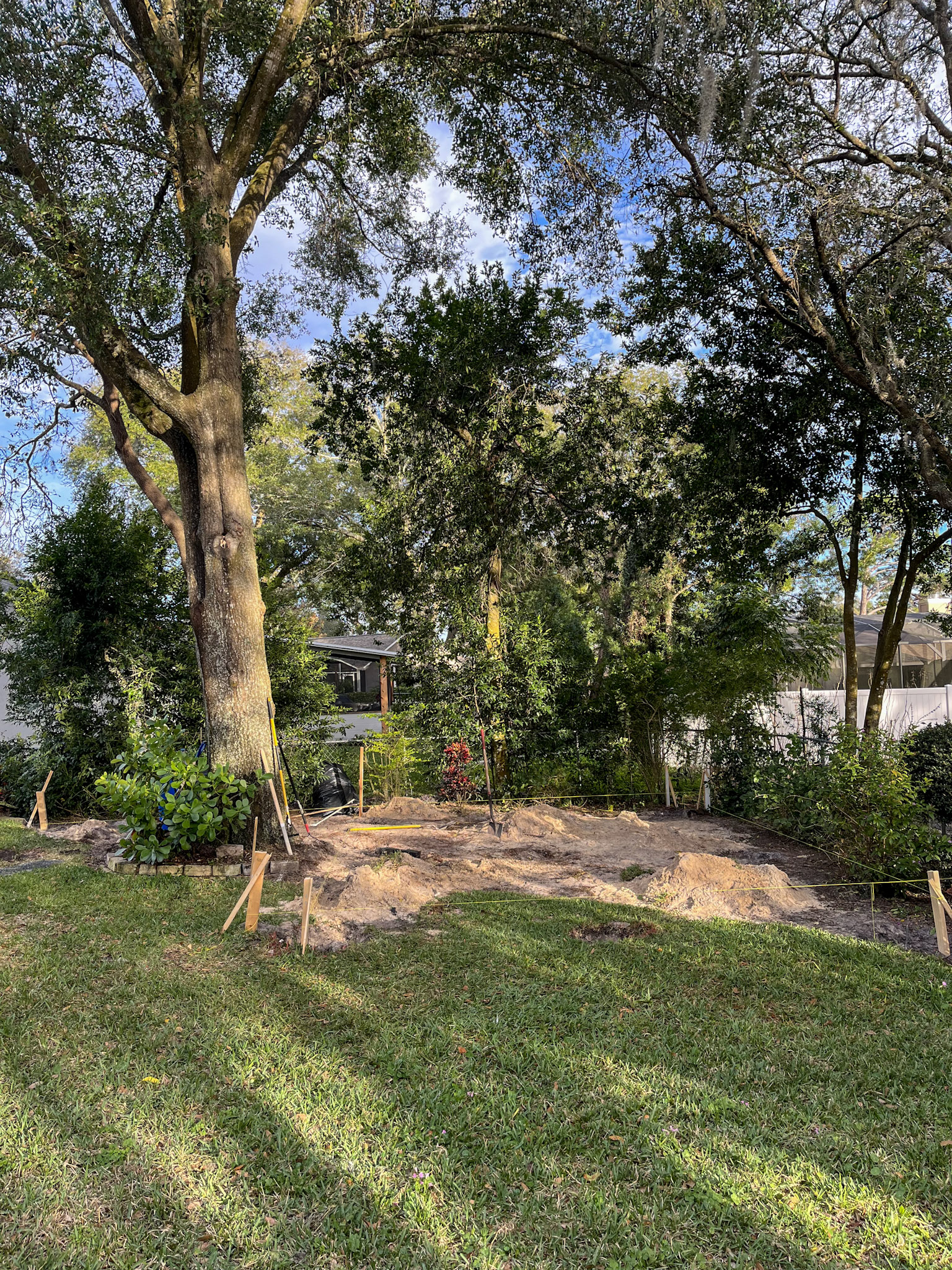 Ground staked out with string lines under the shade tree where the deck will be built