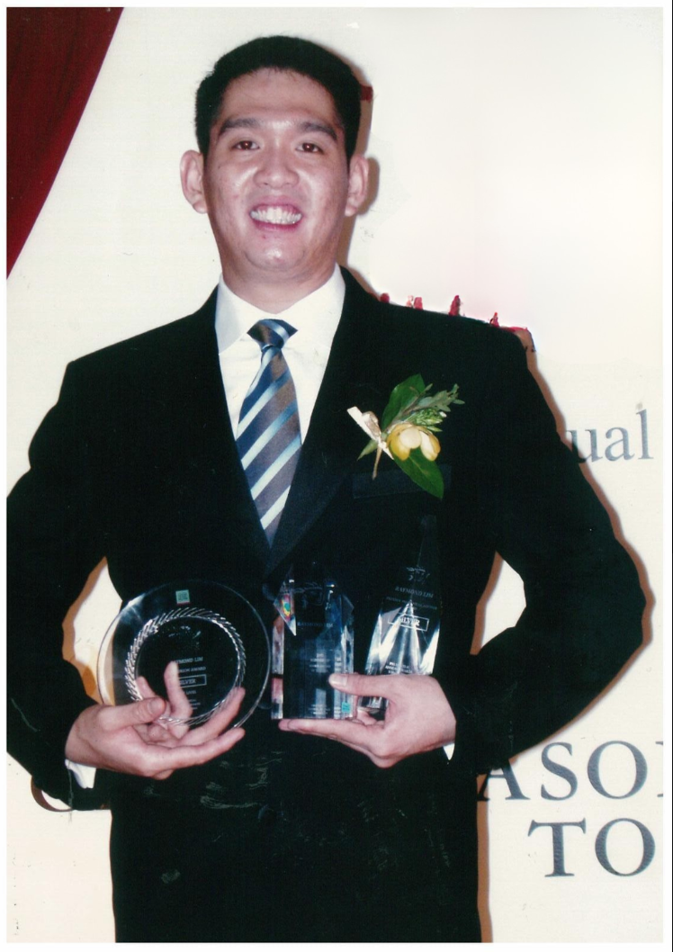Raymond Lim holding industry producer awards on stage