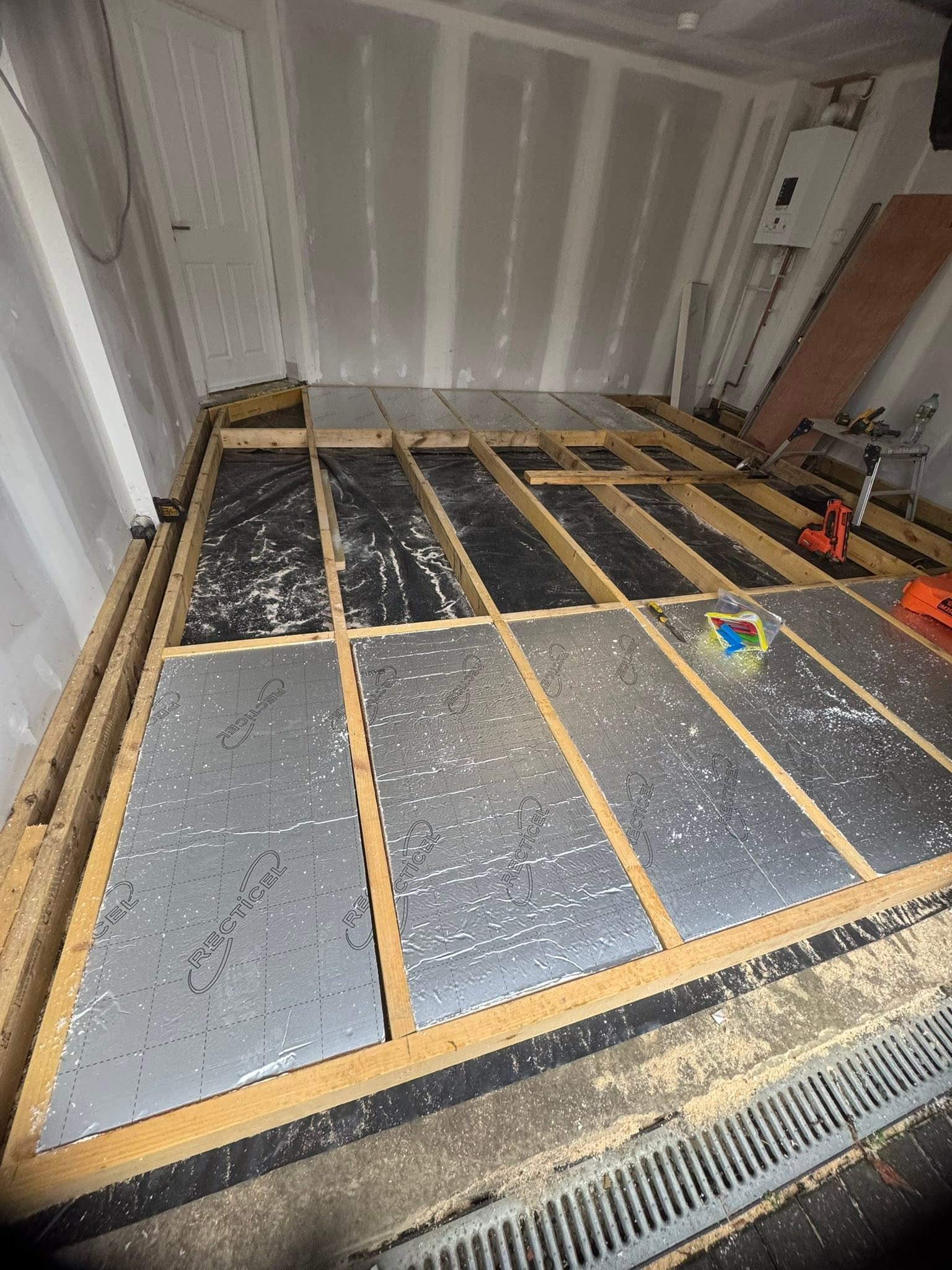 Insulated timber floor structure for garage conversion with damp proof membrane and rigid insulation by SJ Joinery & Building