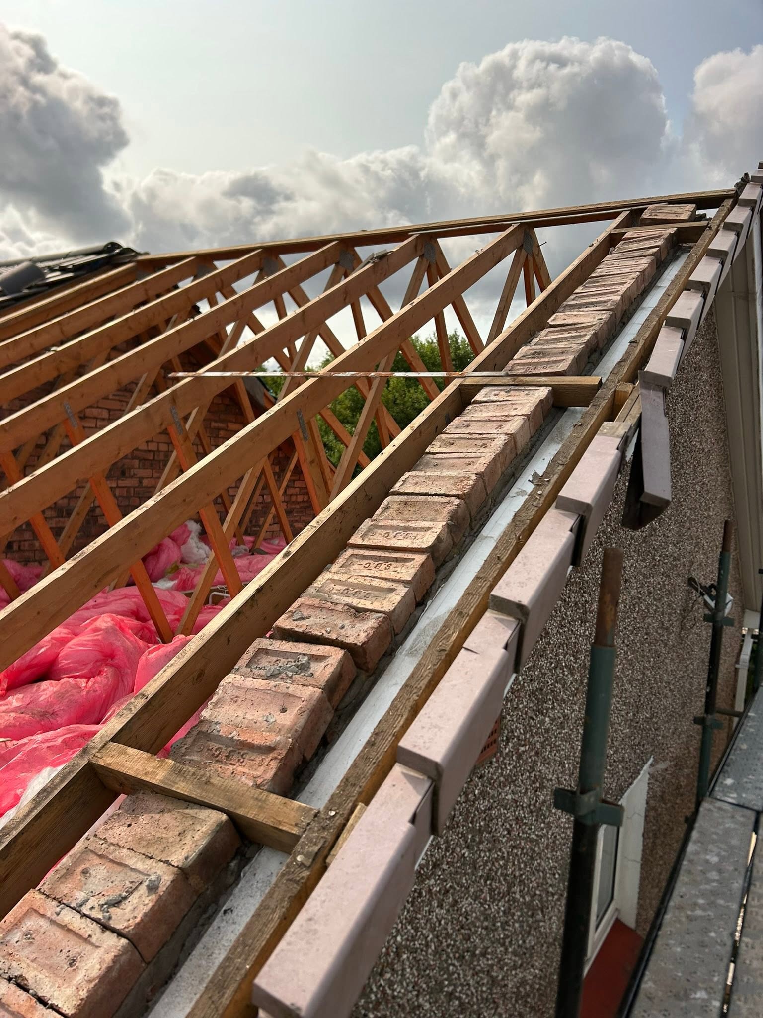 Structural roof truss framing and gable-end brickwork for residential home extension by SJ Joinery & Building