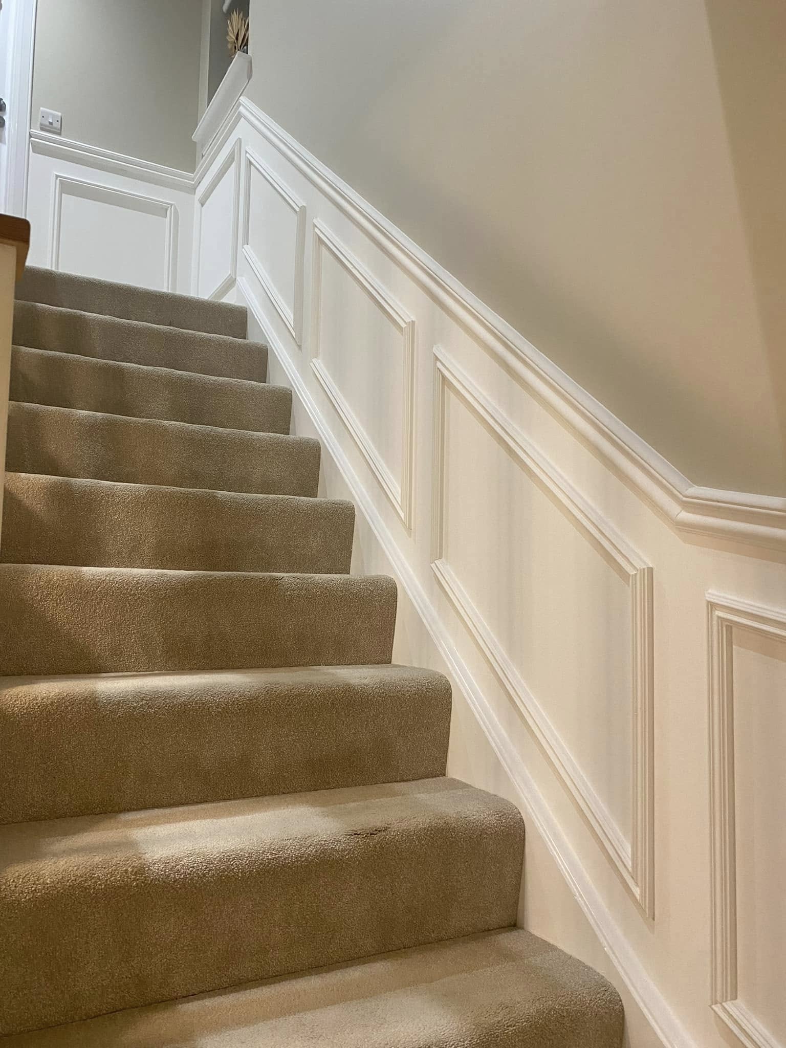 Precision angled staircase wall panelling and wainscoting mouldings in satin white by SJ Joinery & Building
