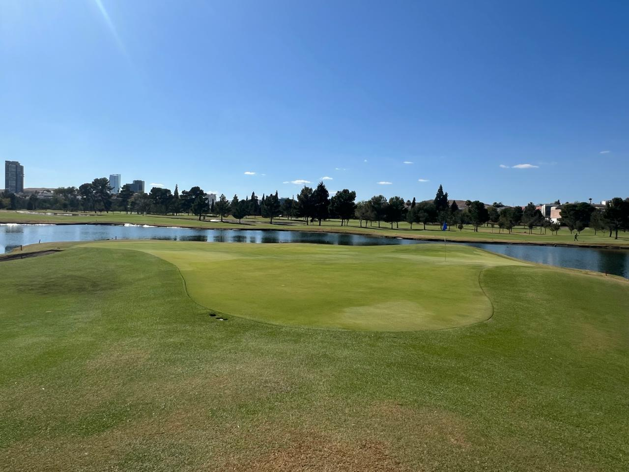Campo de golf costero con lagos, bunkers y vegetación nativa