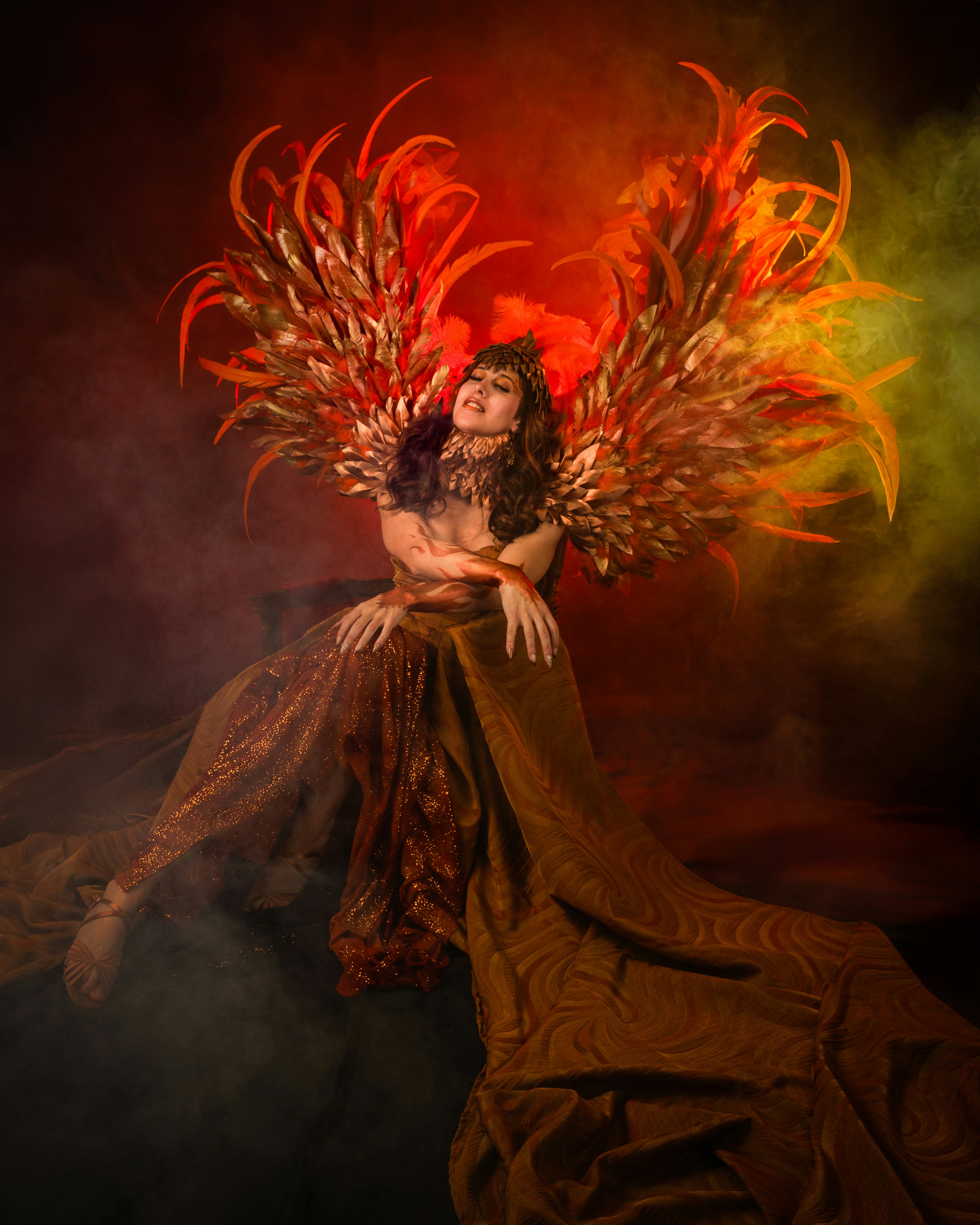 Painting of a woman in a flowing amber gown with wings of red and gold flame