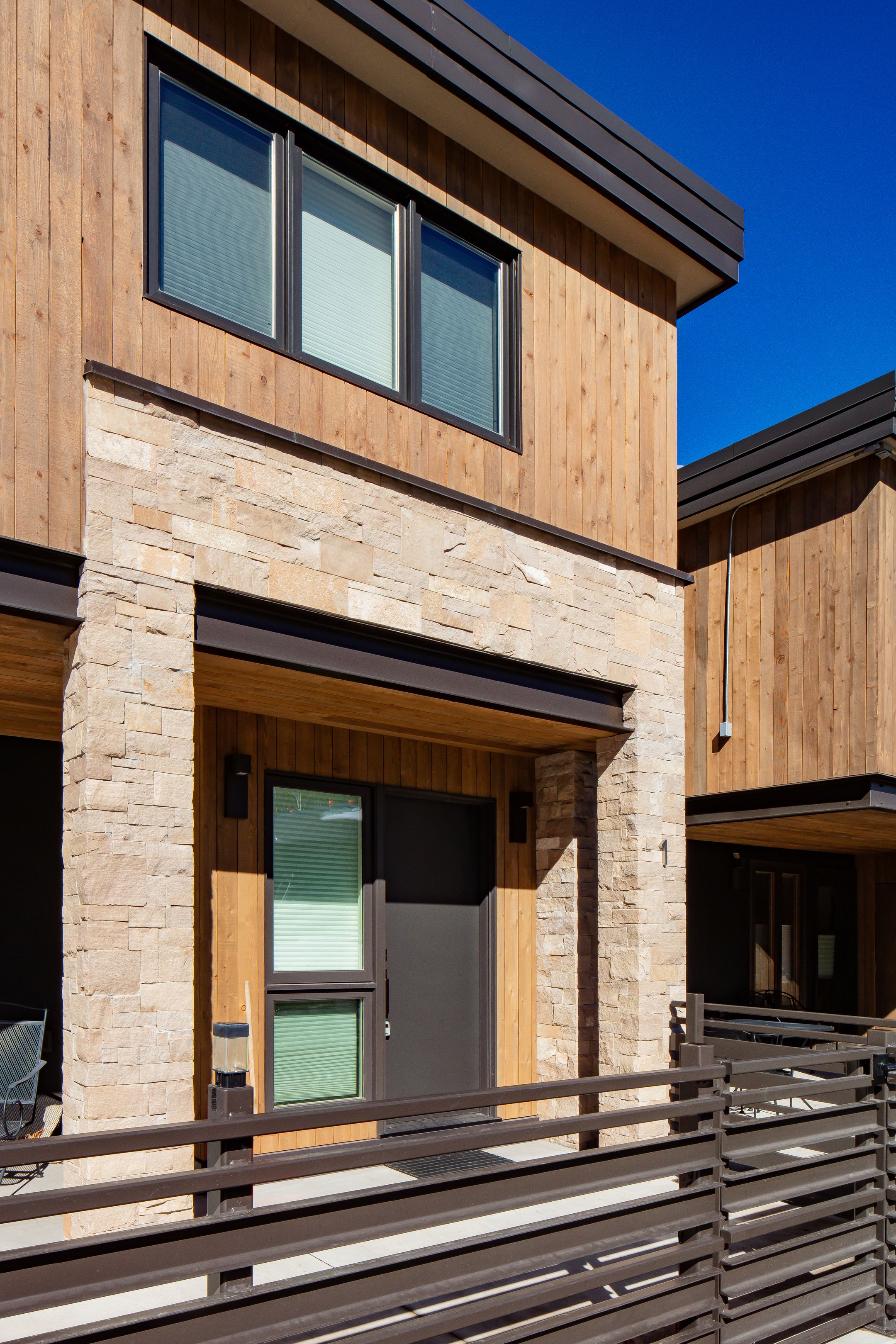 Unit 1 vertical architectural detail of stone and timber entryway — Highlands Villas, Aspen, CO