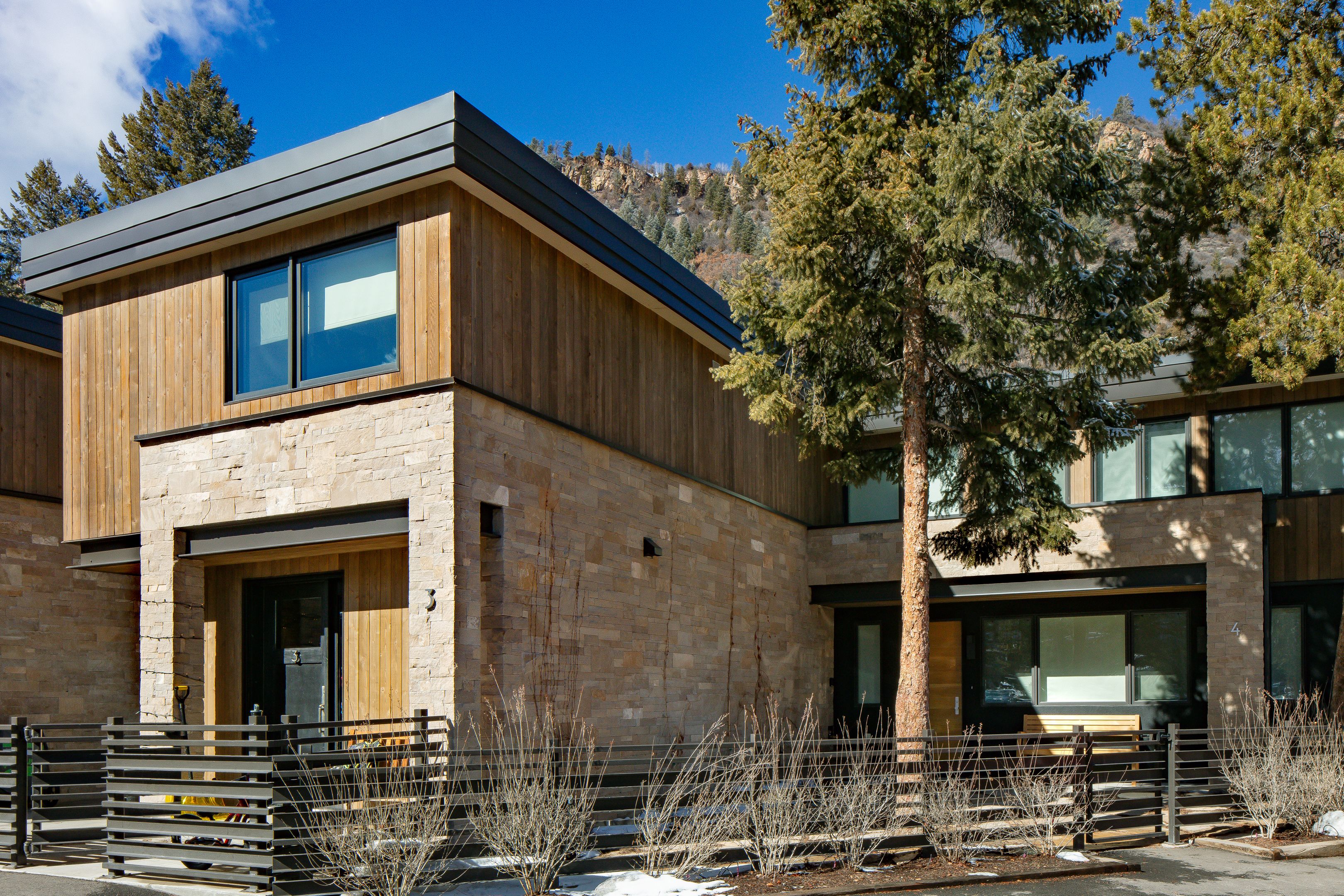 Unit 3 exterior architectural view showcasing stone masonry and vertical timber siding — Highlands Villas, Aspen, CO