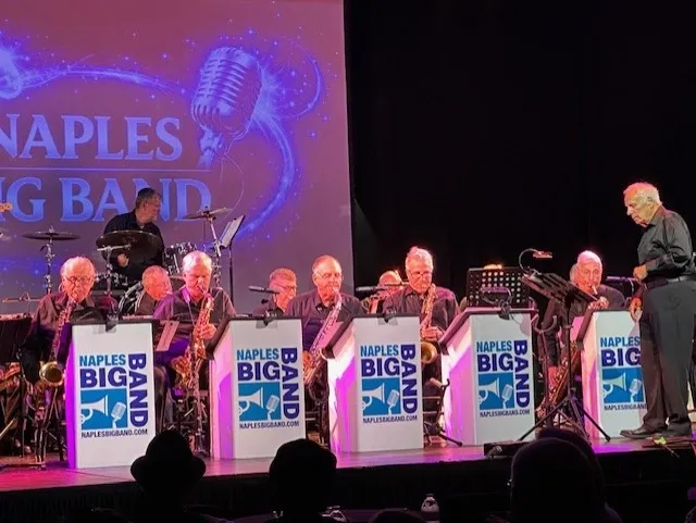Naples Big Band performing on stage with illuminated bandstands and saxophone section