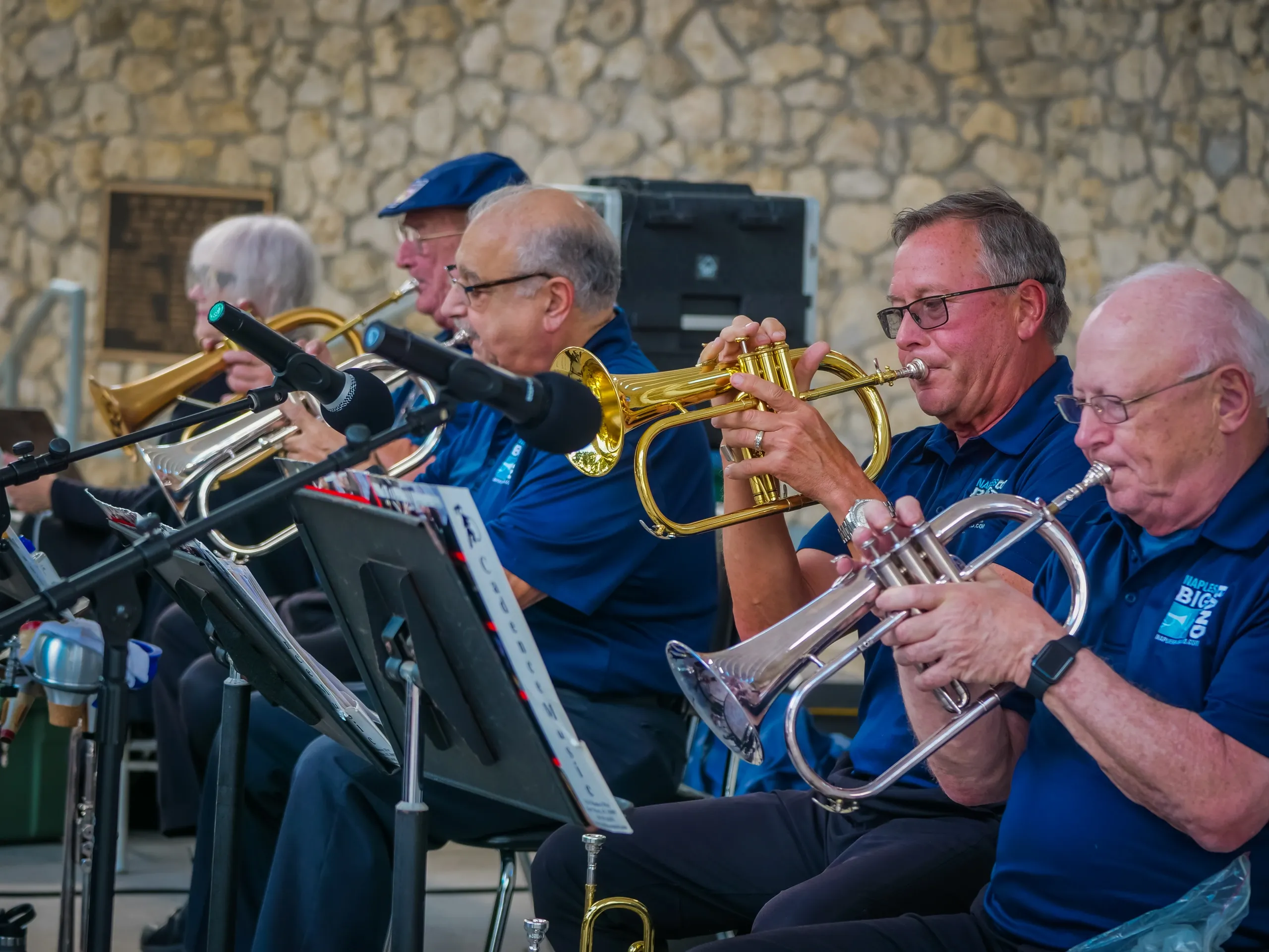 Flugelhorn and trumpet section performing together in matching Naples Big Band polo shirts