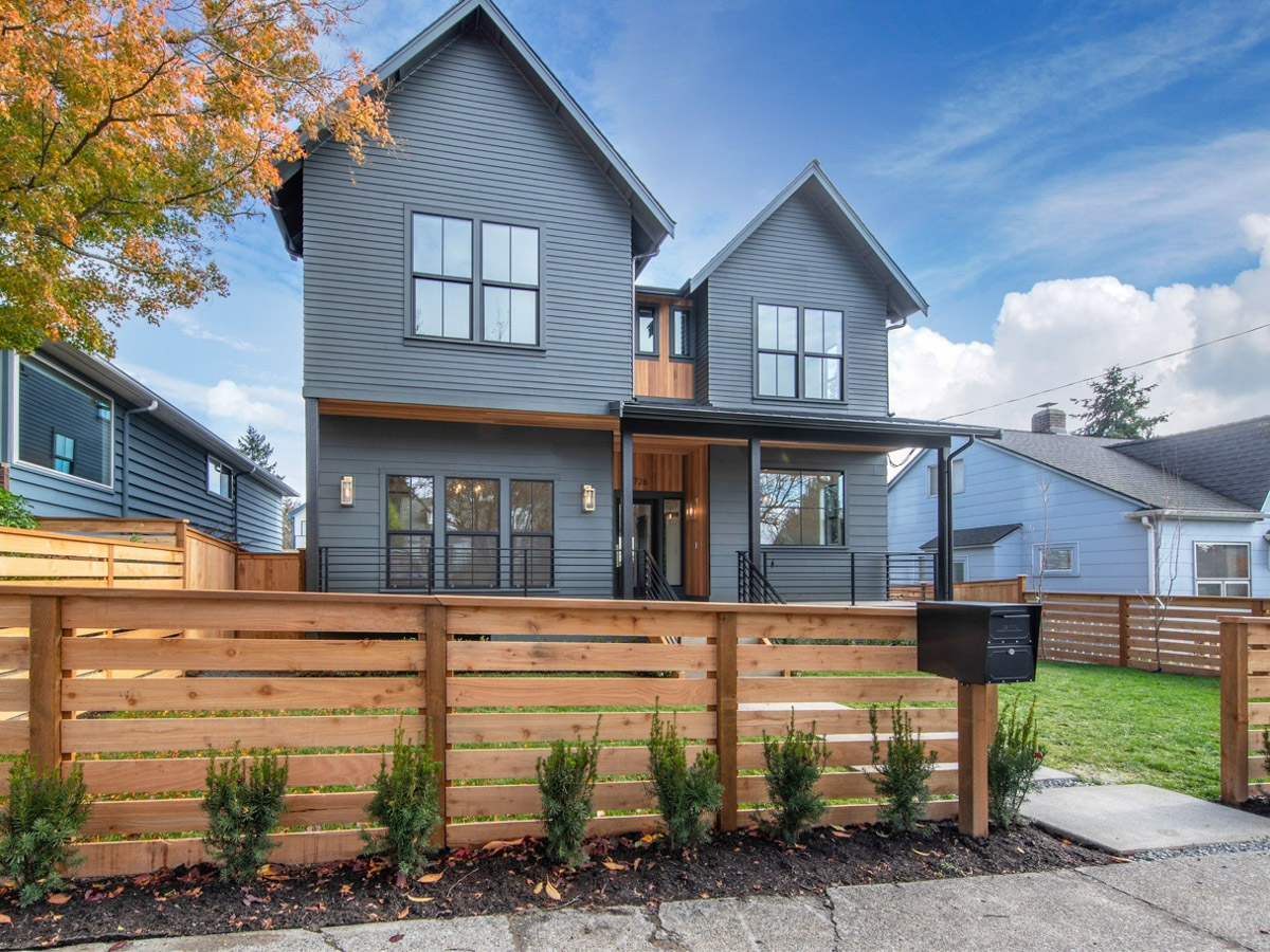 Front of new construction home in Seattle with cedar wood fence, fiber cement lap siding and charcoal architectural shingle roofing