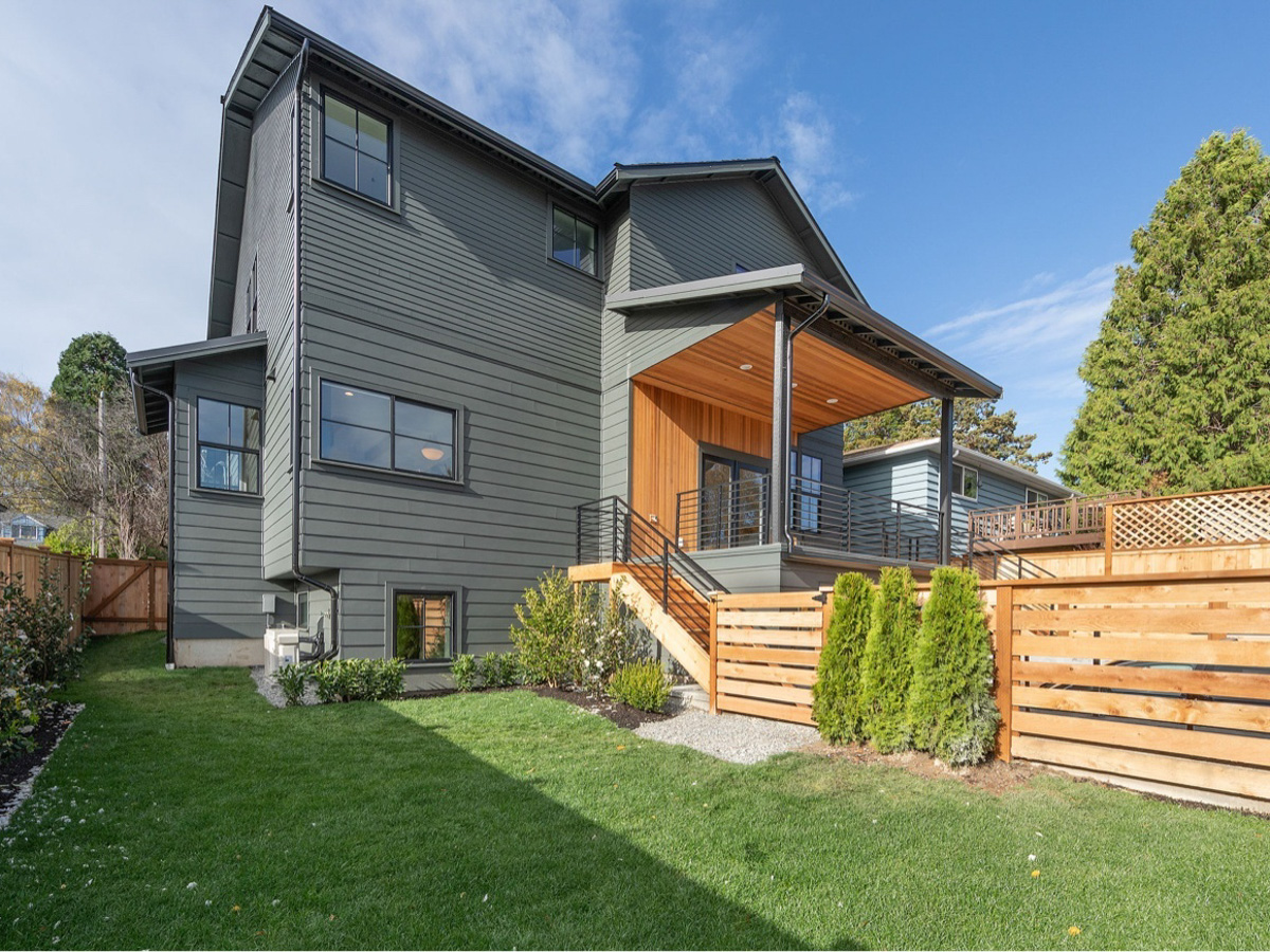 Fiber cement siding installation with cedar wood accents and standing seam metal porch roof on a Seattle WA home