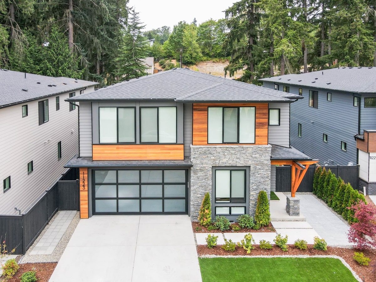 Elevated aerial view of architectural shingle roof installation, Burnished Amber cedar accents, and driveway