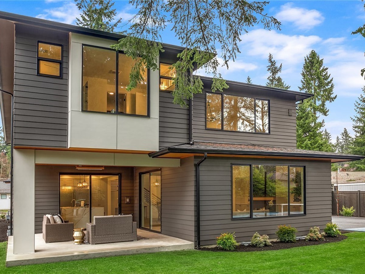Rear exterior elevation with covered patio, modern gray lap siding, and architectural shingle roof