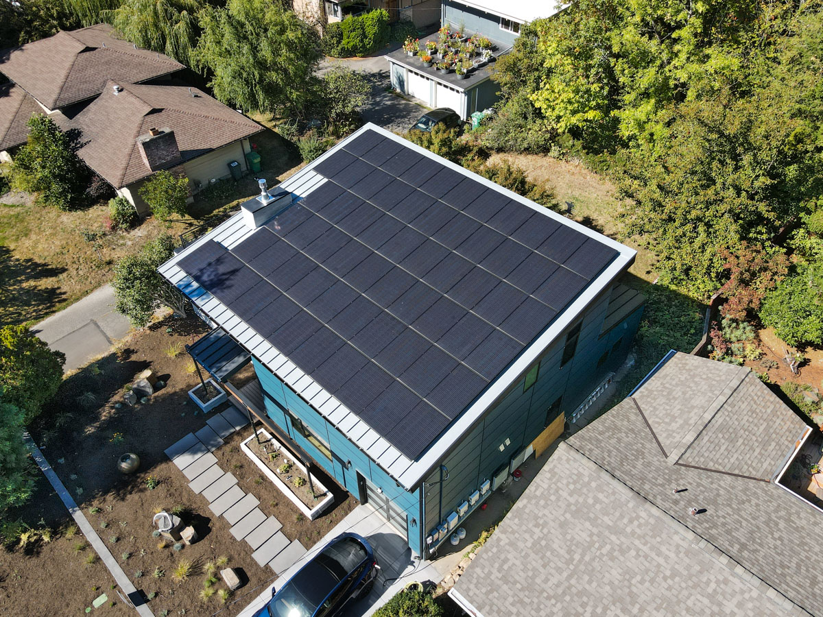 Overhead aerial view highlighting standing seam metal roof framing and full 16KW high-efficiency solar panel layout