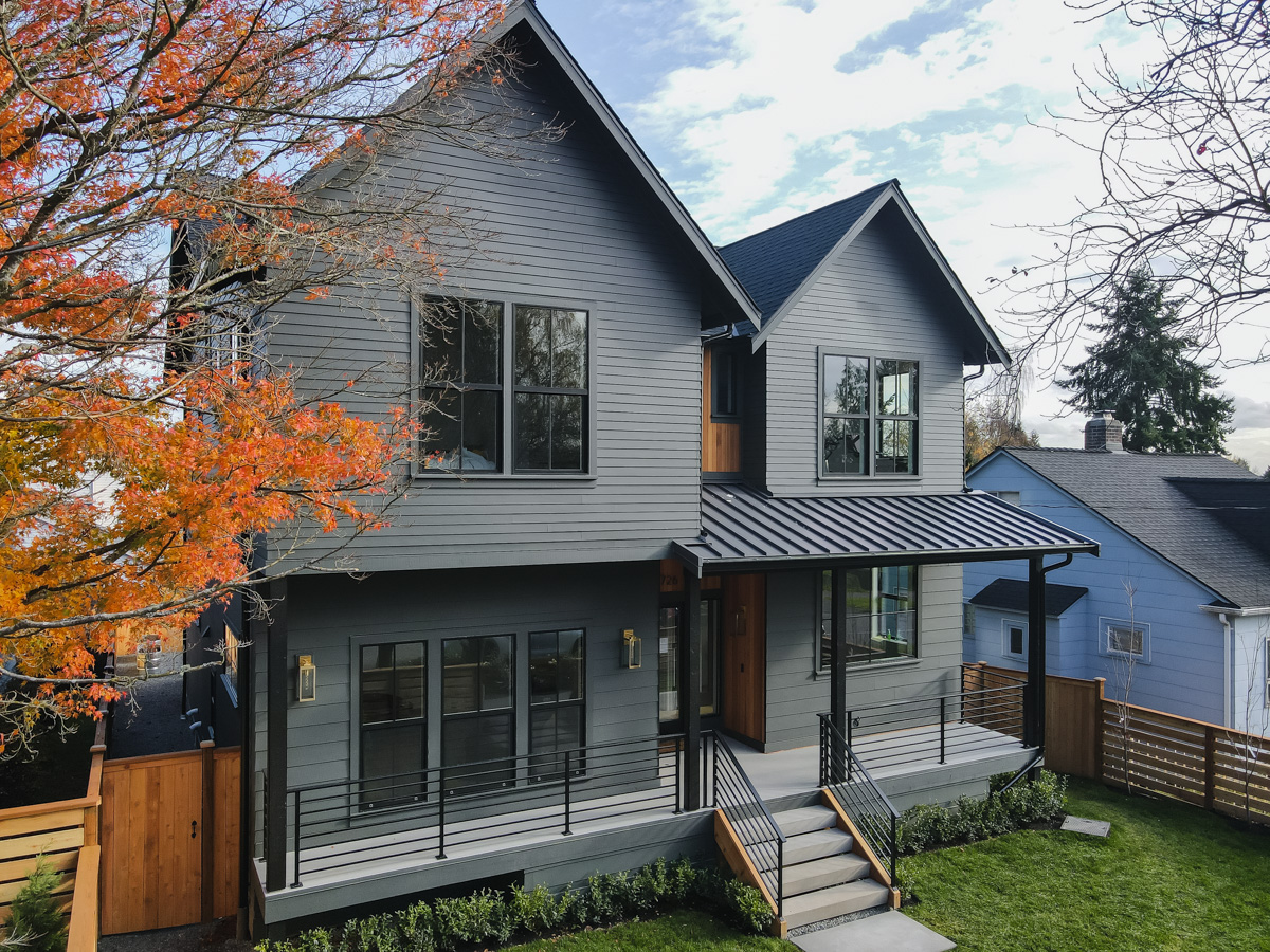 Full front landscaped view with modern steps, black handrails, autumn maple tree, and precision fiber cement siding