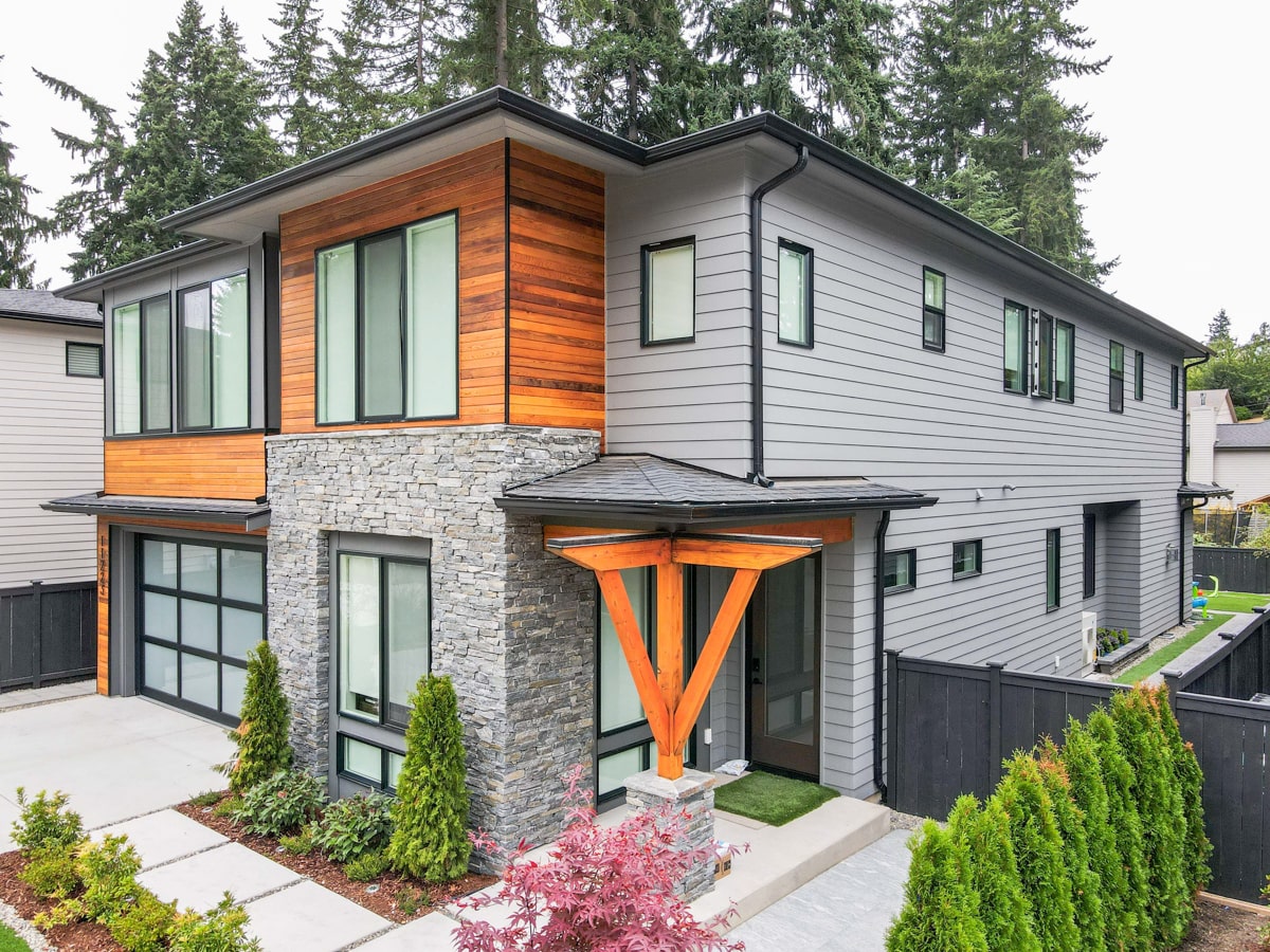 Cedar siding and stone veneer on the upper facade of a Kirkland WA home with architectural shingle roofing