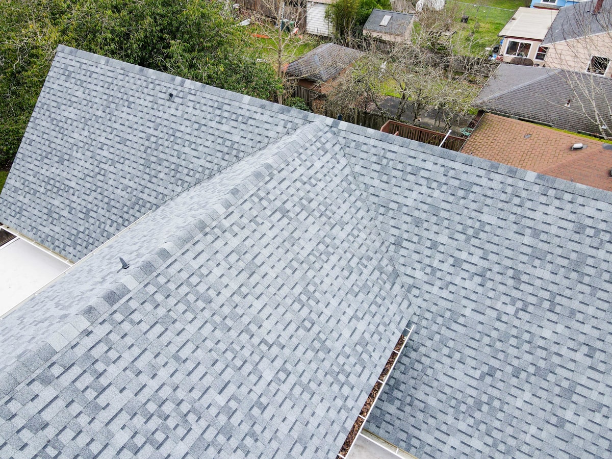 Overhead aerial view of gray architectural shingle roof pattern, ridge caps, and valley lines on Seattle WA home