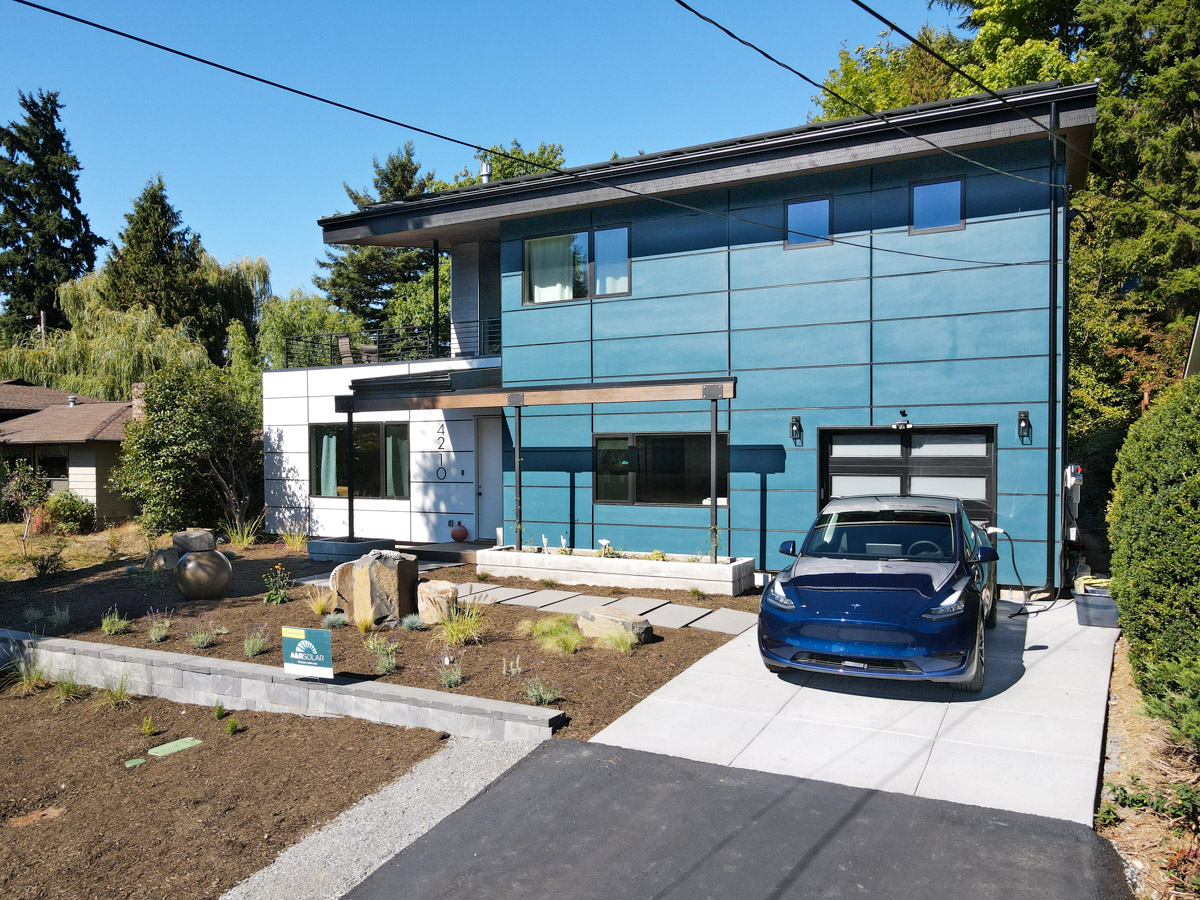 Angled street perspective showing landscaped driveway, driveway entrance, and contemporary exterior architecture