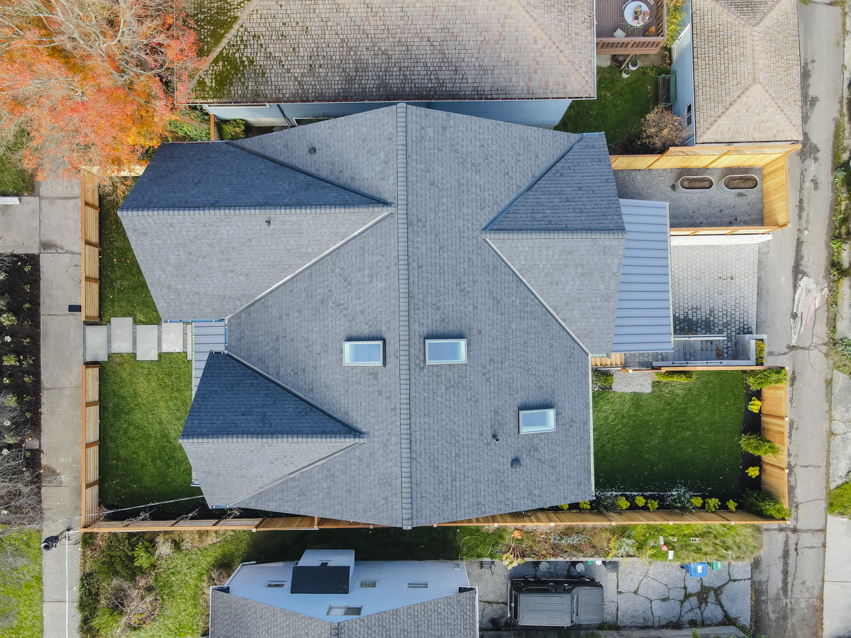 Bird's-eye architectural roof view displaying ridge caps, hip valleys, ventilation vents, and skylights