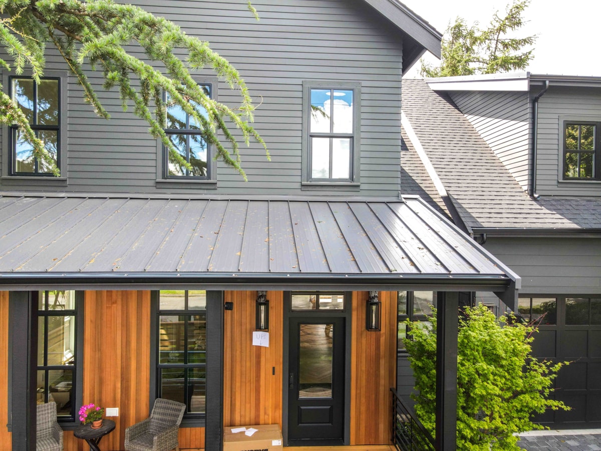 Close-up of standing seam metal roof and James Hardie fiber cement siding on a new construction home in Seattle WA