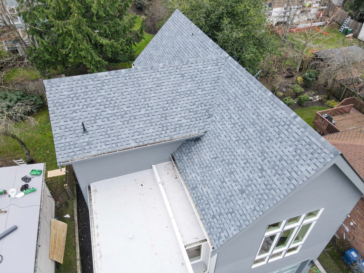 Light gray shingle roofing above the garden of a Seattle WA home by Best Quality