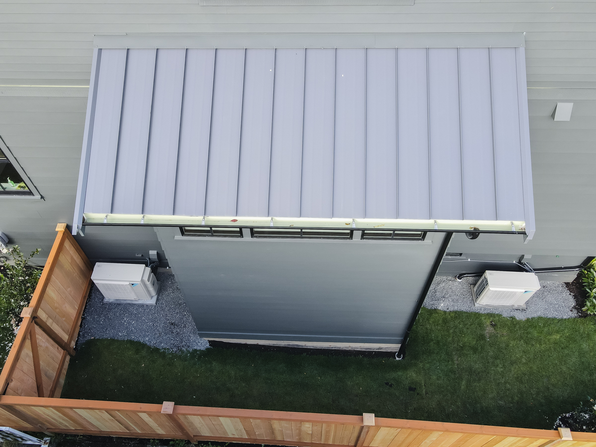 Top-down view of standing seam metal awning installation with clean vertical ribs and custom perimeter flashing