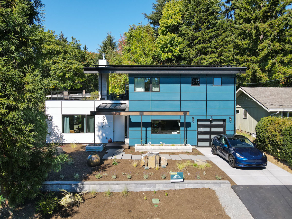 High-resolution full property view showing completed modern rebuild, rooftop solar array, and front landscaping