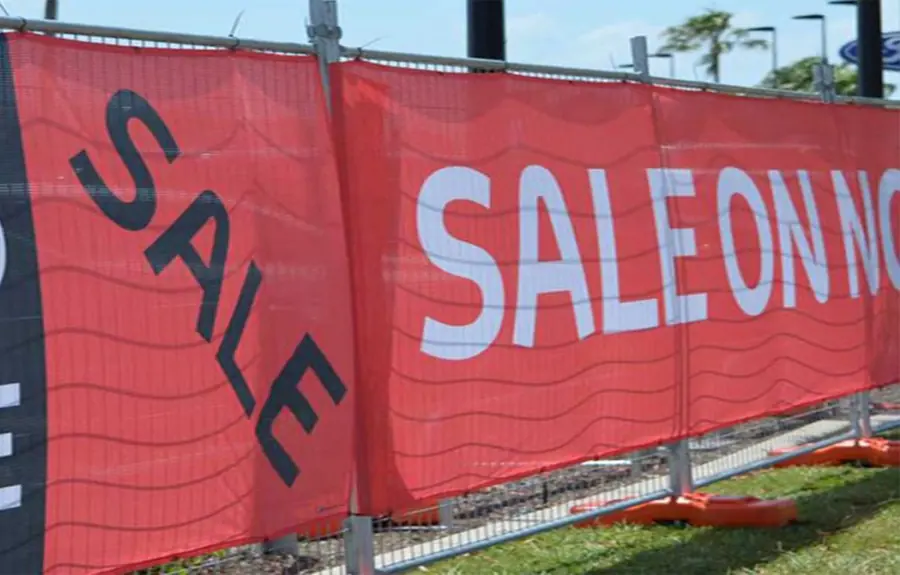 Red sale banners on a temporary fence