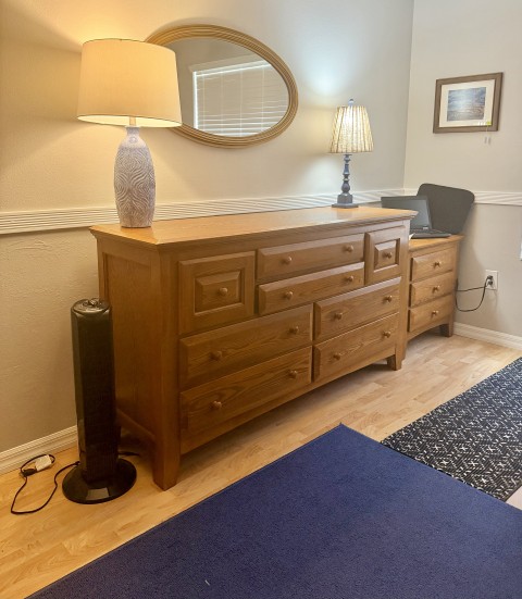 Large solid oak multi-drawer bedroom dresser with lamps and oval mirror