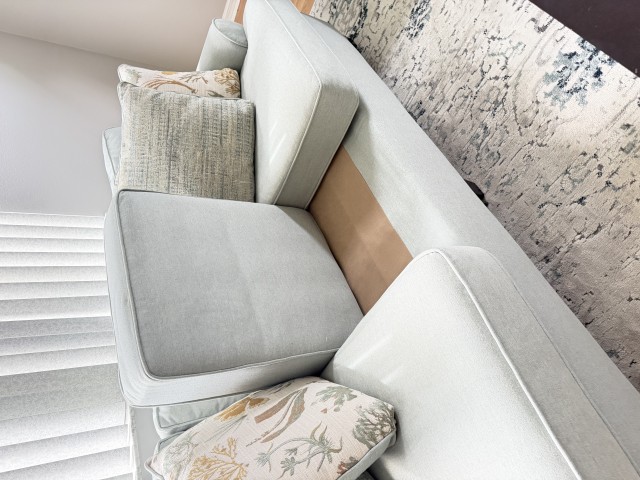 Light blue upholstered sofa with coastal decorative accent pillows