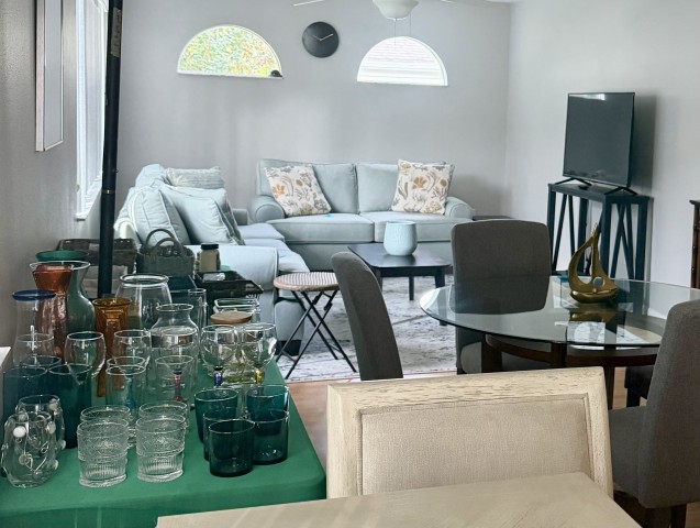 Living and dining room layout with glassware table, round glass table, and sofa