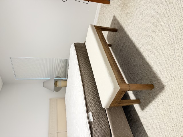 Mattress with cushioned wood bench at the foot of the bed