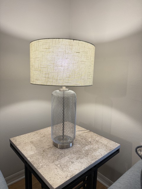 Contemporary wire mesh base table lamp on stone side table