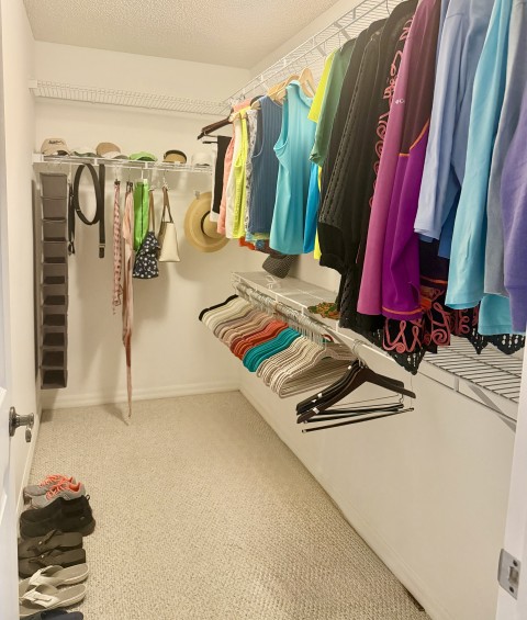 Spacious walk-in closet with organized clothing, shoe organizer, and accessories
