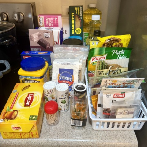 Countertop organizer with pantry essentials, flour, Lipton tea, spices, and seasonings