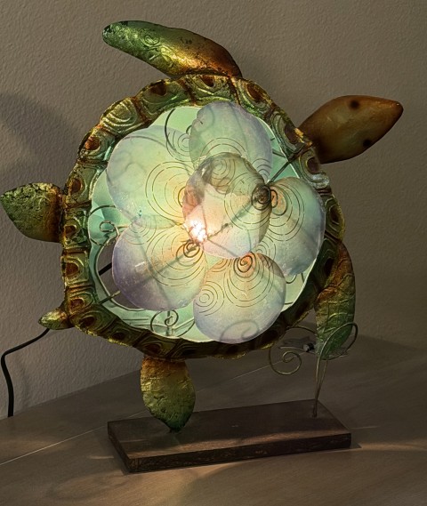 Decorative illuminated sea turtle table lamp with iridescent shell and wood stand