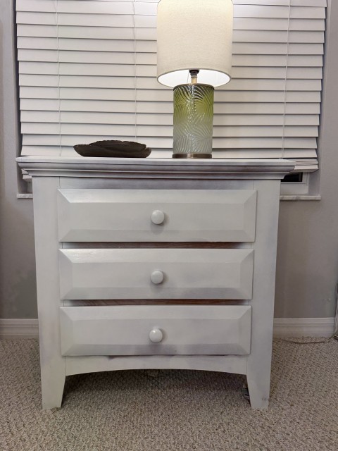 White three-drawer nightstand with decorative glass accent lamp