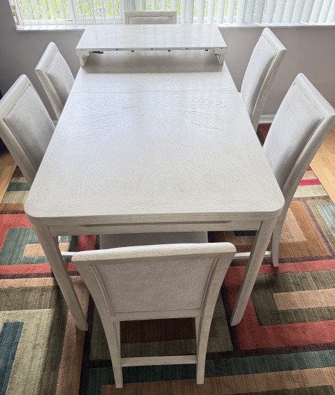 Whitewashed wood dining table set with extension leaf and six upholstered chairs