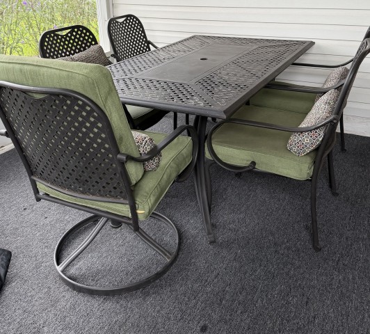 Outdoor screened patio dining set with rectangular metal table and swivel armchairs with sage green cushions