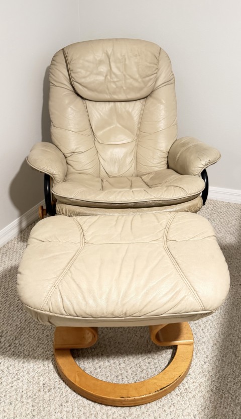 Beige leather swivel recliner armchair with matching footrest ottoman and light wood base