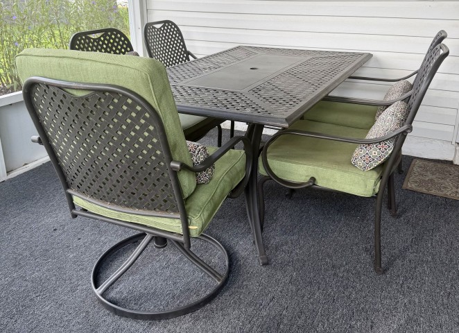 Patio metal dining set with rectangular table and 4 armchairs with green cushions