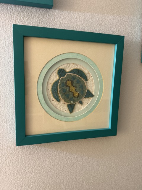 Framed handmade sea turtle paper artwork in teal frame