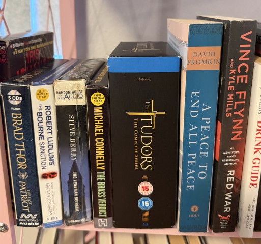 Bookshelf with audiobooks, The Tudors complete series box set, and thrillers