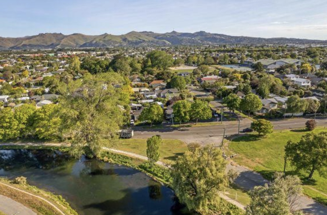 Aerial view of Avonside with the Avon River, parkland and the Port Hills in the background